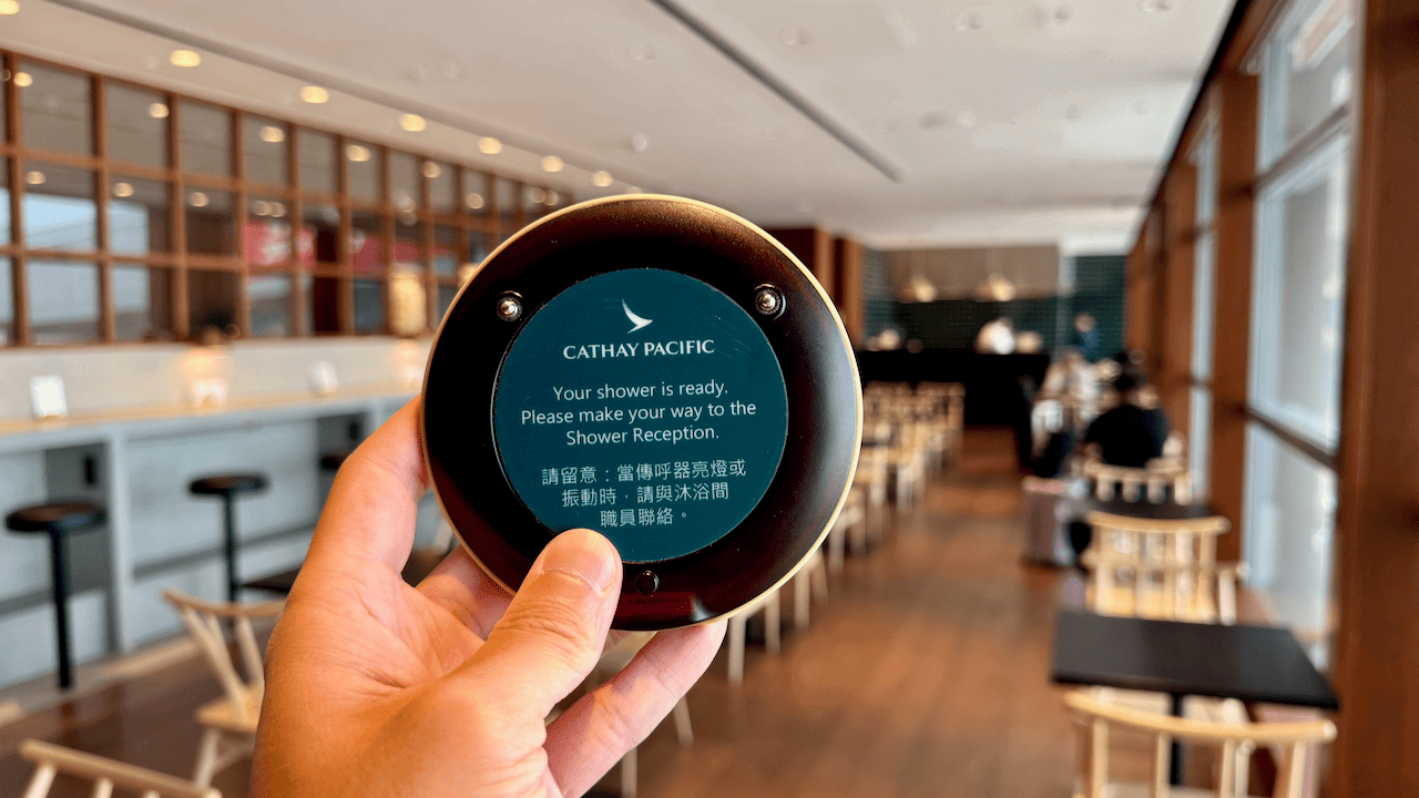 國泰航空沐浴間呼叫器,顯示「您的淋浴間已準備就緒,請前往沐浴間接待處」