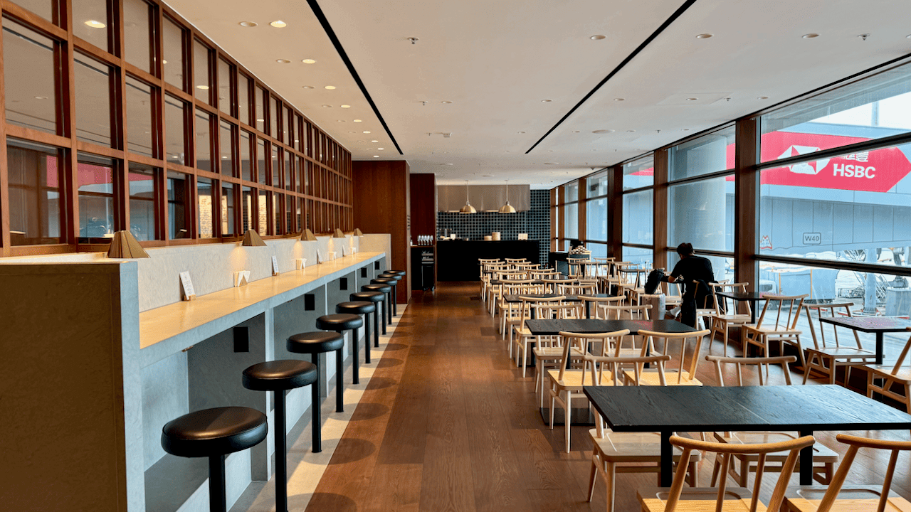 寬敞的餐廳內部,設有吧台座位及木椅餐桌,落地玻璃窗外可見滙豐銀行標誌