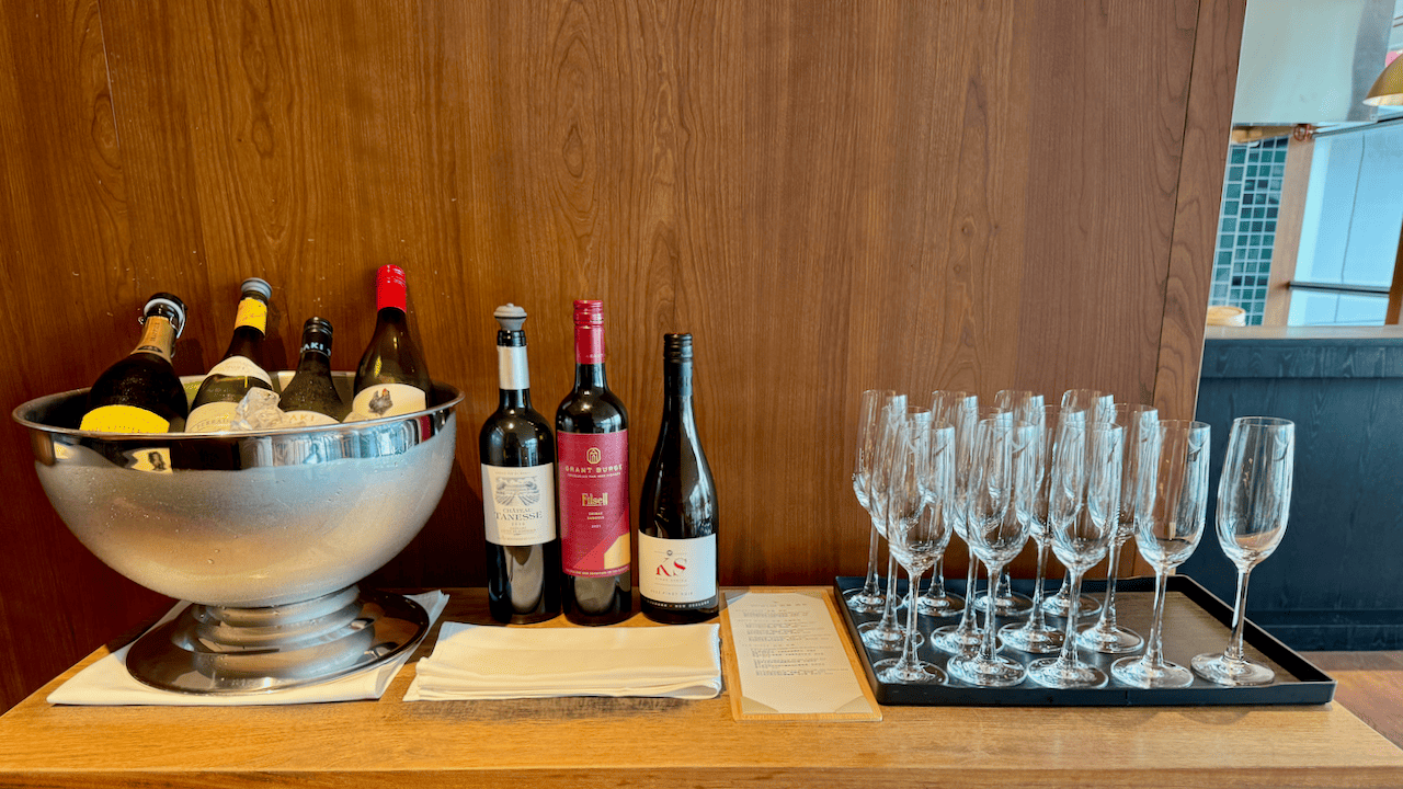 貴賓室酒水吧台,設有冰桶、多瓶紅白葡萄酒及一排空酒杯